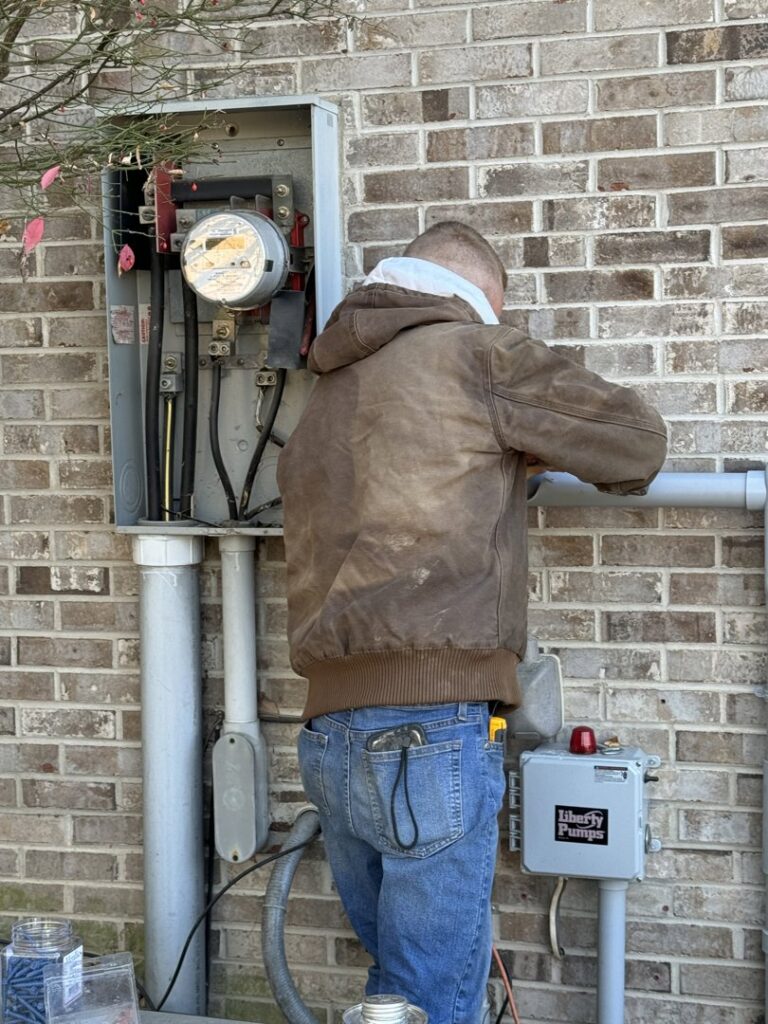 An electrician from Rudis Electrical LLC working on an outdoor electrical meter and service entrance in Scranton, PA.