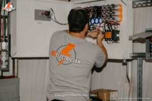 An electrician from 4G Electrician performing work on an electrical control panel in Dallas, TX