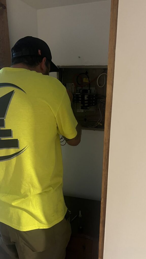 An electrician working on an open electrical panel for Advance Electrical Contractors in Milwaukee, WI.