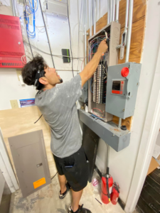 An electrician working on an electrical service panel and wiring for C&S Electrical Services LLC in Ashburn, VA.