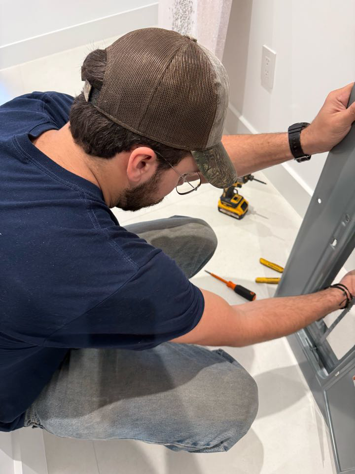 An electrician working on an electrical panel with tools at Electric Service & Repair, Inc in Miami, FL.