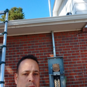 An electrician working on an outdoor electrical panel for Illuminate Electric, Inc. in Denver, CO