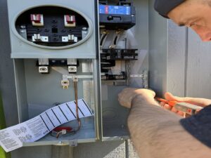 An electrician from Intel-electric working on an outdoor electrical panel in Anchorage, AK