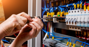 An electrician working on an electrical panel with a screwdriver at Kot Electric LLC in Kent, WA.