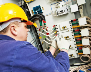 An electrician from Lewis Electric working on a complex electrical panel in Macon, GA