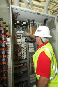 An electrician working on a large electrical control panel at MetroPower, Inc. in Albany, GA.