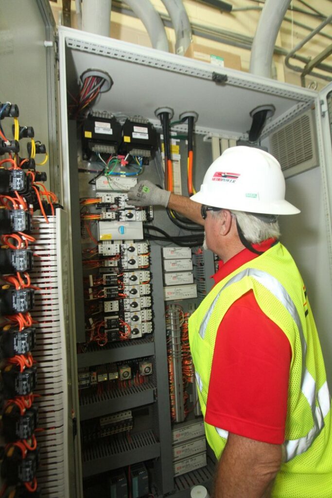 An electrician working on a large electrical control panel at MetroPower, Inc. in Albany, GA.