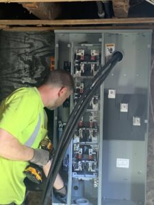 An electrician from Moss Contracting working on an electrical service panel in Philadelphia, PA.