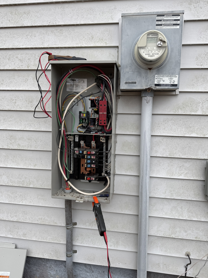 An electrician working on an open electrical panel with a multimeter at a home in Morehead City, NC by SGA Electric, LLC.