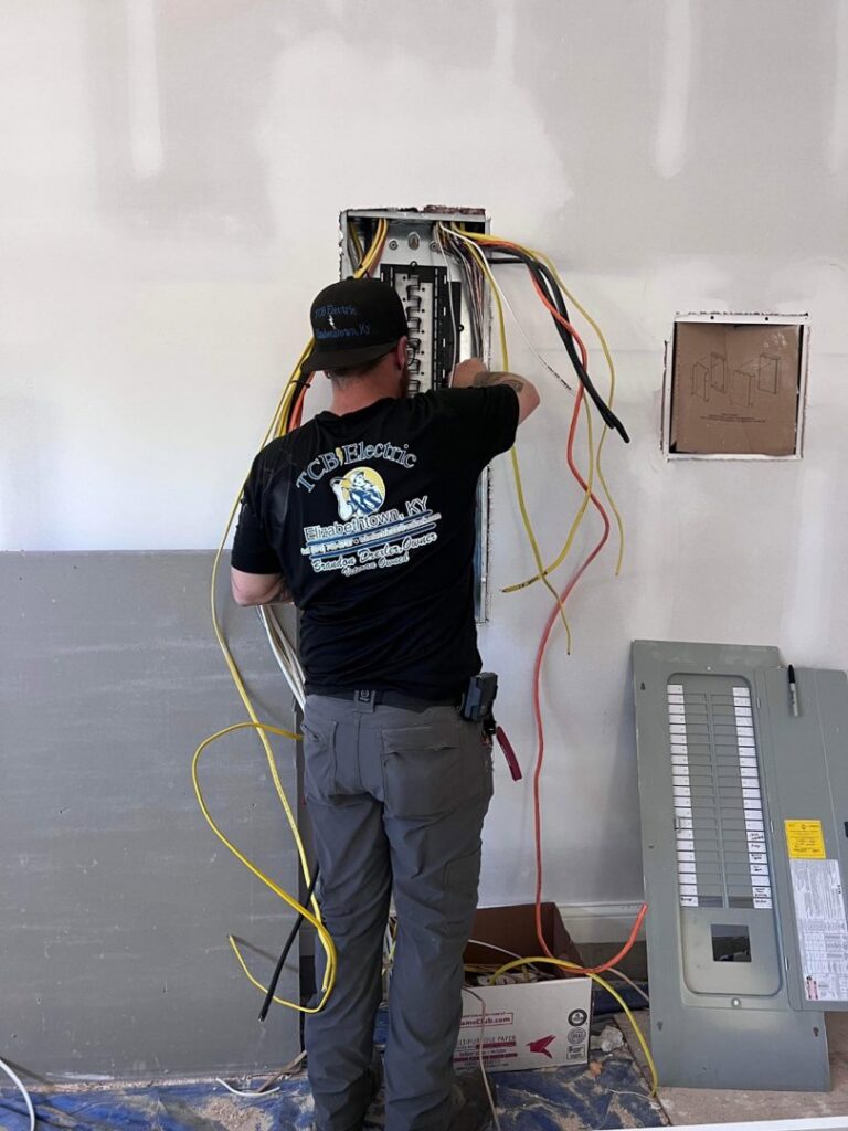 An electrician from TCB Electric LLC working on an electrical panel during an installation or repair in Elizabethtown, KY.