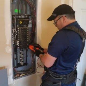 An electrician from Tovar Electric working on an electrical panel in a home or business in Downy, CA.