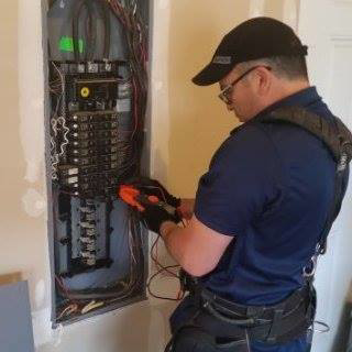 An electrician from Tovar Electric working on an electrical panel in a home or business in Downy, CA.