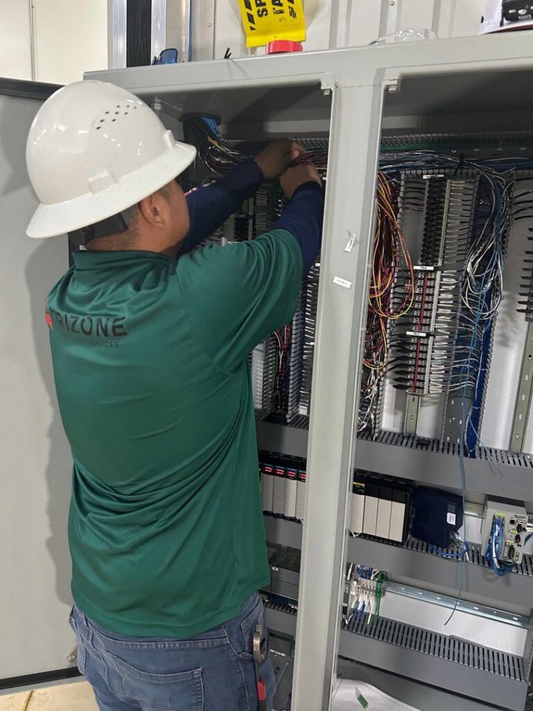An electrician from Trizone Electric, LLC working on an electrical panel, connecting wires in Houston, TX.