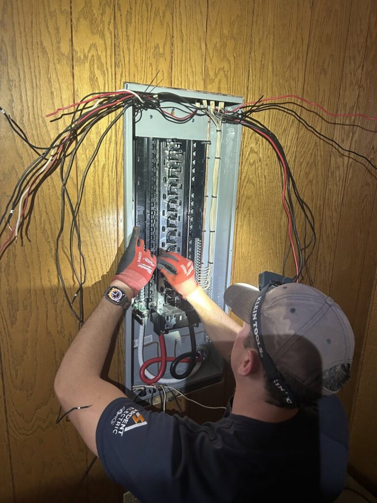 An electrician from Ardent Electric working on wiring an electrical panel in Erie, PA.