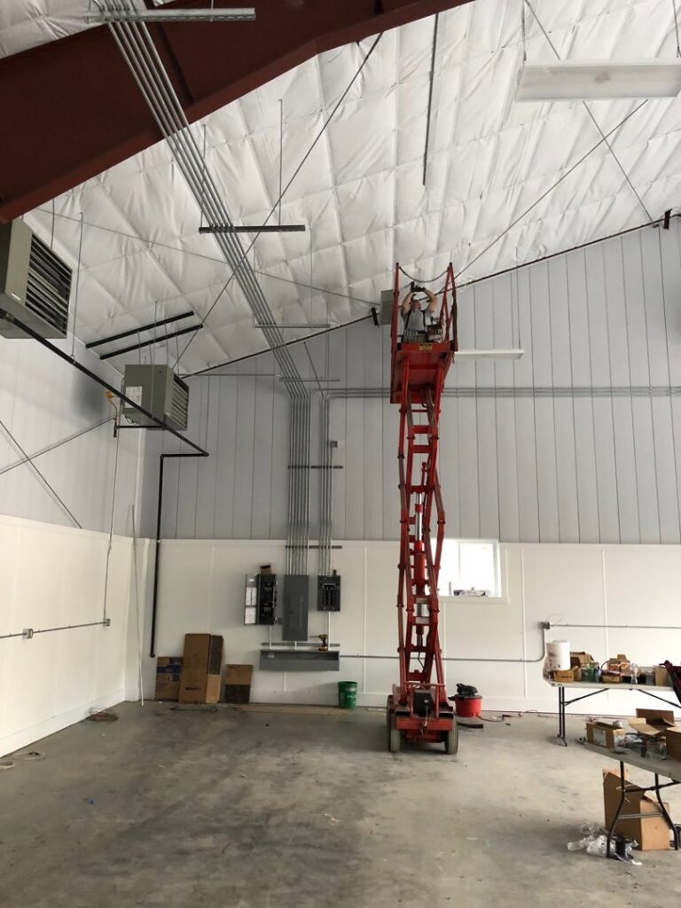 An electrician from Valley Electric Inc in Lewiston, ID, working on complex wiring inside an electrical panel.