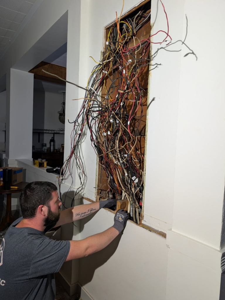An electrician working on exposed electrical wires during a job for GMD Electric in Springfield, OR.