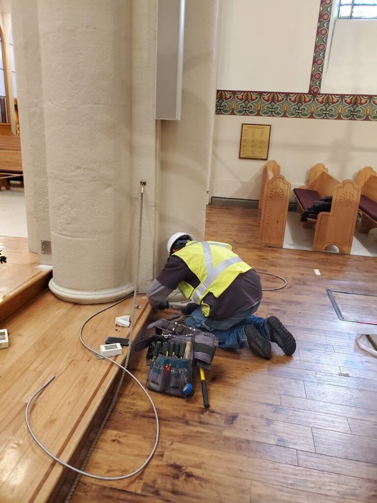 An electrician from Allied Electric working on floor wiring installation in Sparks, NV.