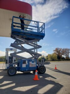 An electrician from D.B. Smart Homes & Security working on a gas station canopy in Sheridan, WY.