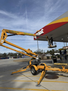 An electrician from Lite Electric working on a gas station sign from a boom lift in Augusta, GA.