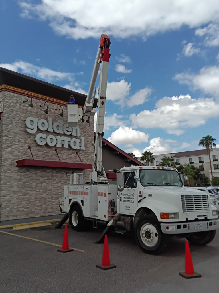 An electrician from Jesse's Electric working on the illuminated Golden Corral sign from a bucket truck in Laredo, TX.