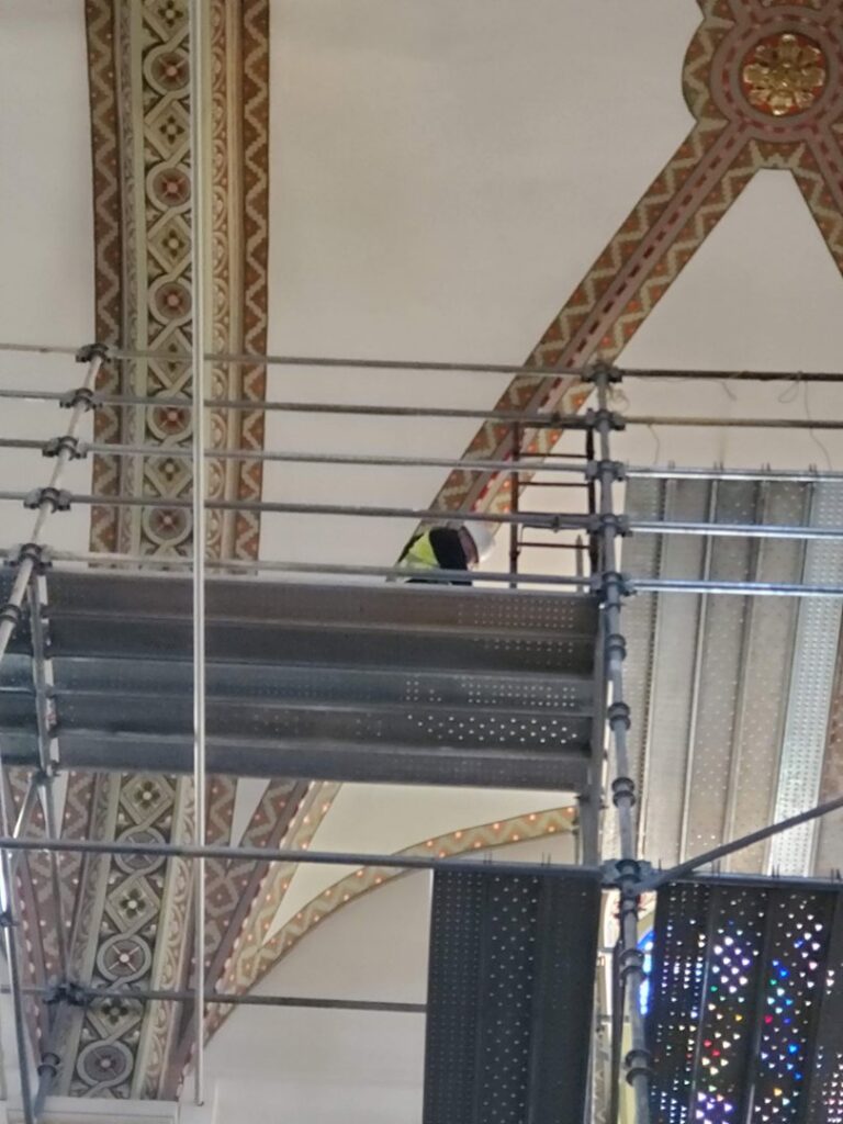 An electrician from Allied Electric working on high ceiling fixtures from scaffolding in Sparks, NV.