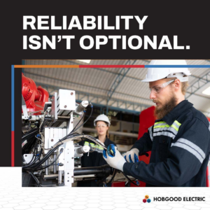 An electrician in safety gear working on industrial machinery and wiring at Hobgood Electric in Winnsboro, SC