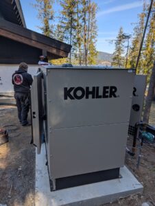 An electrician working on an open Kohler standby generator for Great Northern Power in Kalispell, MT.