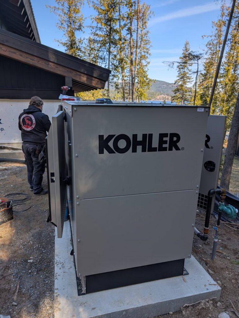 An electrician working on an open Kohler standby generator for Great Northern Power in Kalispell, MT.