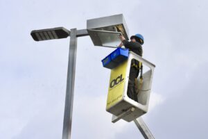 An electrician working on a large outdoor light fixture from a bucket lift for Oregon Commercial Lighting in Eugene, OR.