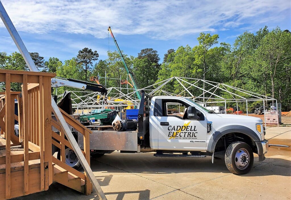 An electrician's hand working on the intricate wiring of an electric motor at Caddell Electric Co Inc in Dallas, TX