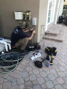 An electrician working on outdoor electrical controls and wiring for Electric Service & Repair, Inc in Miami, FL.