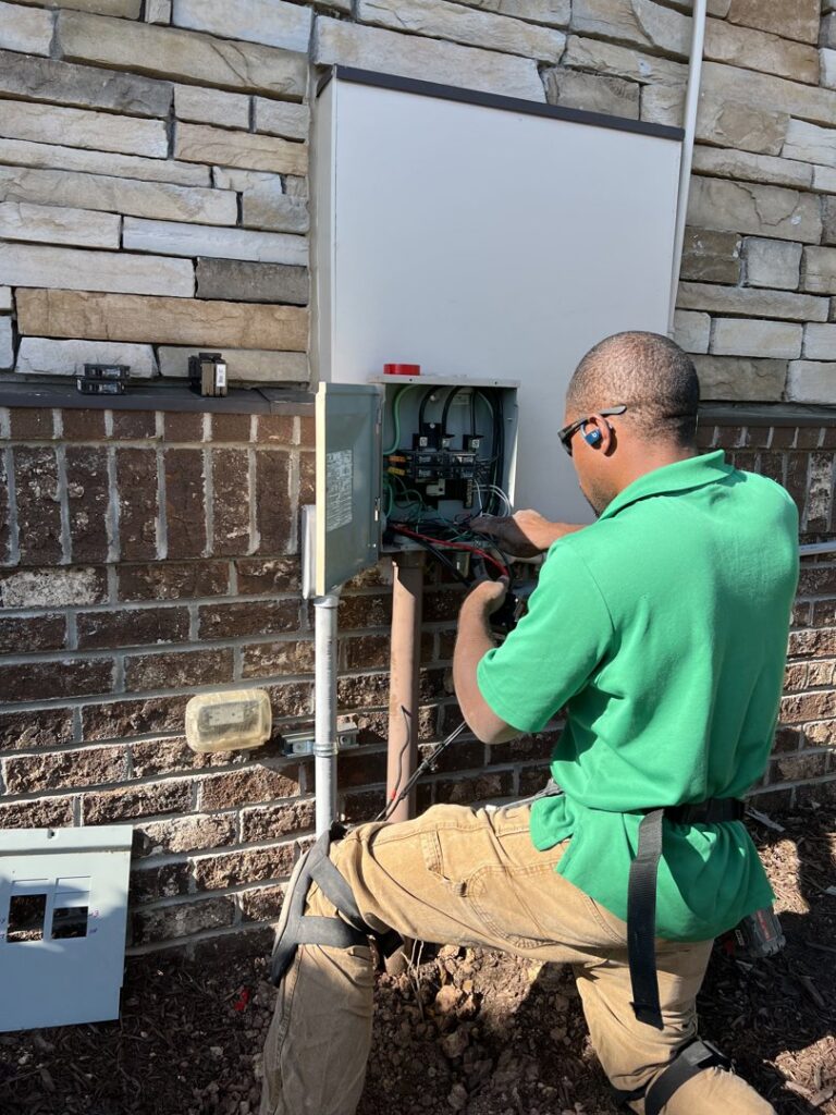 An electrician from Green Volt Electric LLC working on an outdoor electrical service panel in Durham, NC.