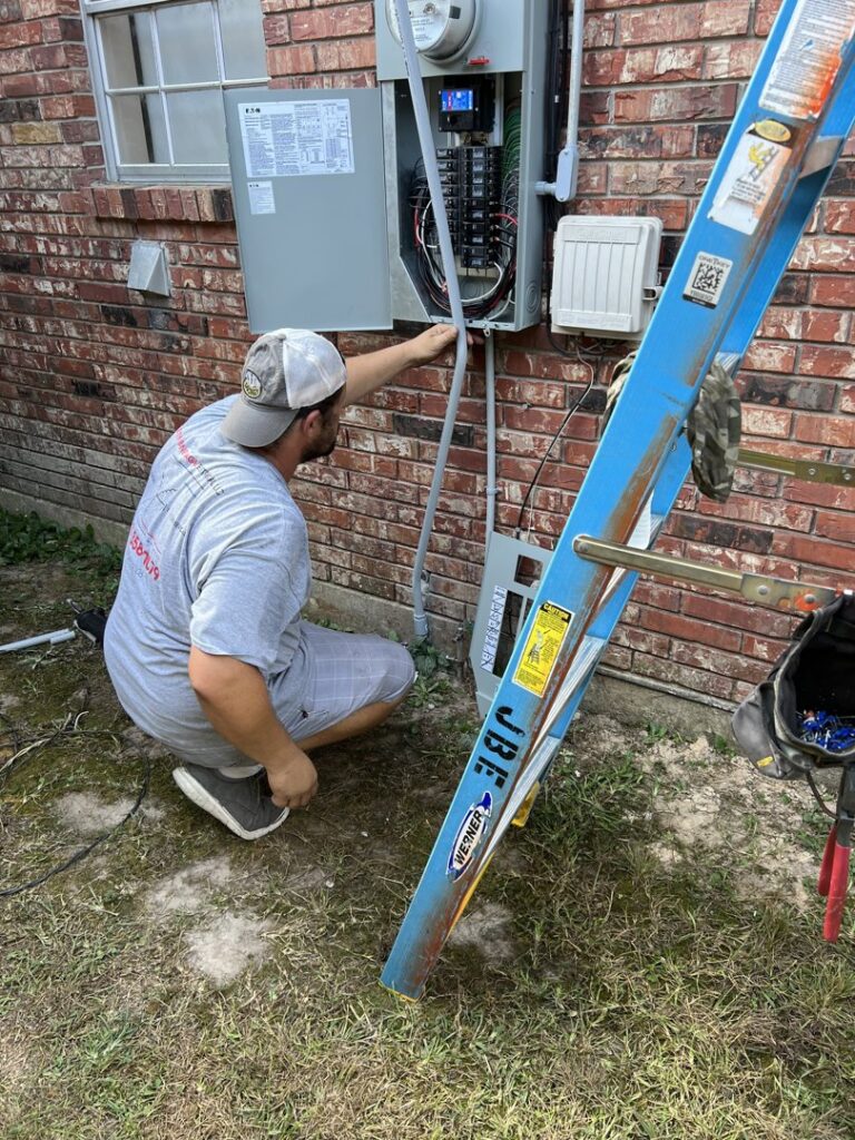 An electrician working on an outdoor electrical panel on a brick house for Justin Benevage Electrical, LLC in Lake Charles, LA