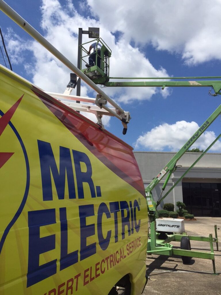 An electrician from Mr. Electric of Montgomery County Alabama working on an outdoor light fixture in Montgomery, AL.