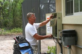 An electrician from Ace Electrical Services working on an outdoor electrical panel in Jacksonville, FL.