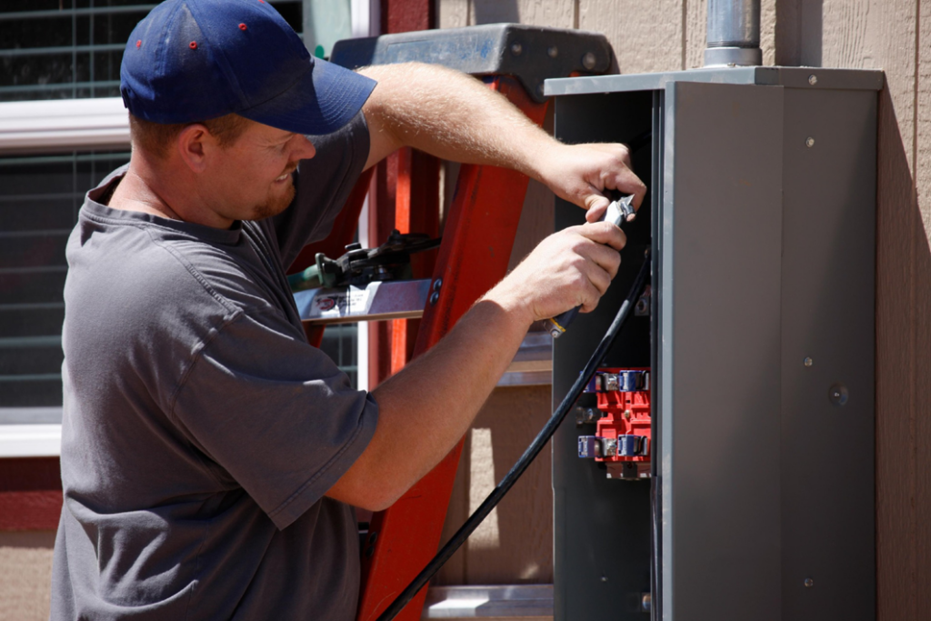 An electrician from EMS Electric of Monroe LLC working on an outdoor electrical panel in Monroe, LA.