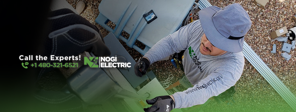 An electrician from Nogi Electric LLC working on an outdoor electrical panel or conduit in Mesa, AZ.
