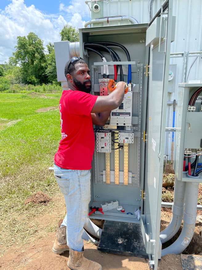 An electrician working on an outdoor electrical panel installation for Savoski's Electrical & AC, LLC in Sunset, LA