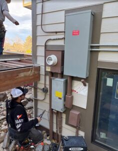 An electrician from Wilson Electrical Contractors working on an outdoor electrical panel and meter in Orlando, FL.