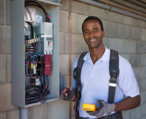 An electrician from Boweaks Electrical Solution LLC working on an electrical panel with a multimeter in Honolulu, HI.