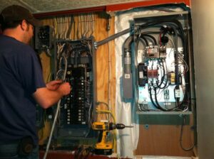 An electrician working on an electrical service panel for President, Cannizzo Electric, Inc. in Rochester, NY.