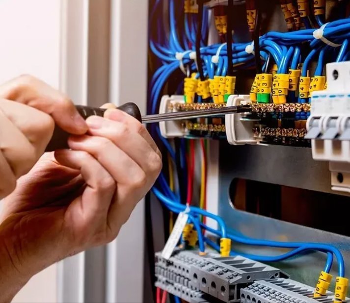 An electrician working on an electrical panel with a screwdriver for Cruz Electrical Services in Wilmington, DE.