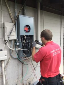 An electrician from Farris Electric LLC working on an electrical panel, connecting wires in Glendale, AZ.