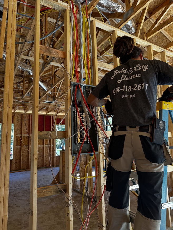 An electrician from Bold City Electric working on an electrical panel during new construction in Jacksonville, FL.
