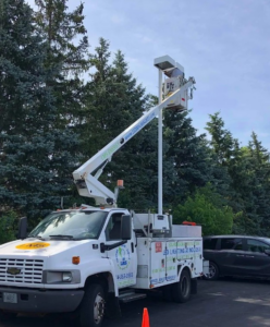 An electrician from LMS Energy working on a pole-mounted light fixture from a bucket truck in Milwaukee, WI.