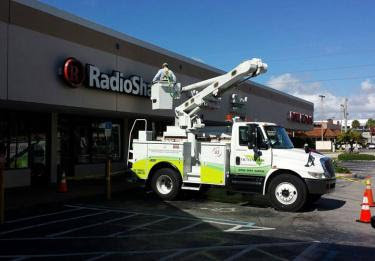 An electrician working on a commercial sign from a bucket truck for Tri-Systems Group, Inc Electrical Service Contractors in Miami, FL.