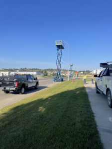 An electrician from On Point Electrical Services working on a street light from a lift in Williston, ND.