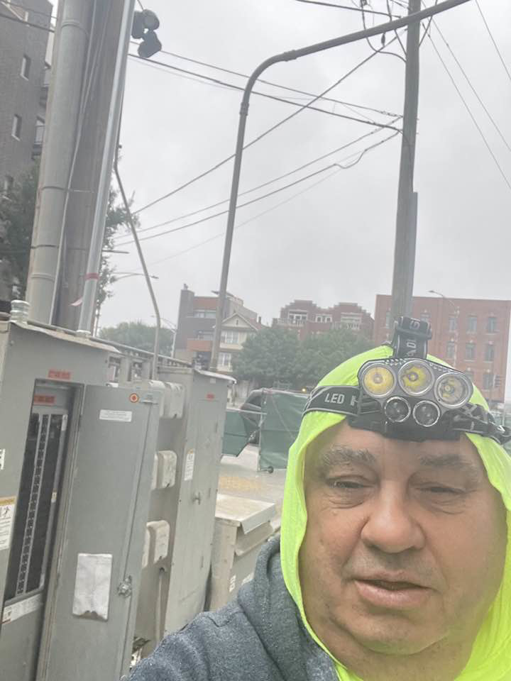 An electrician from Sttrango Electric Company working on outdoor electrical utility boxes in Chicago, IL.
