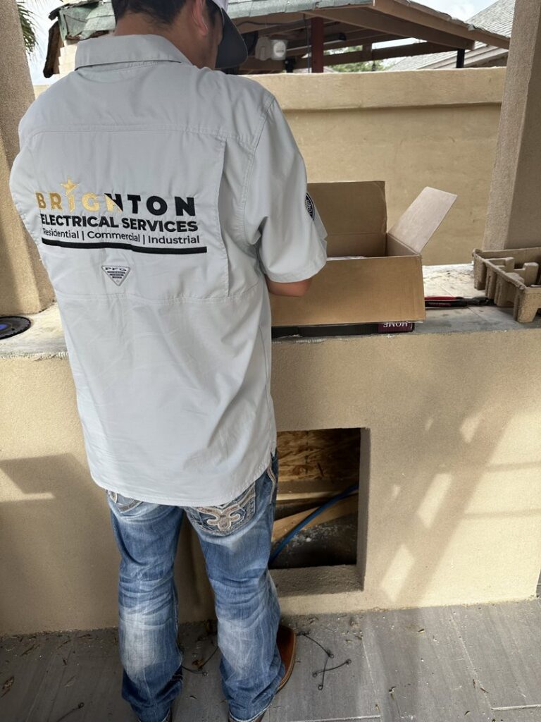 An electrician from Brighton Electrical Services working on an electrical installation in a wall opening in Laredo, TX.