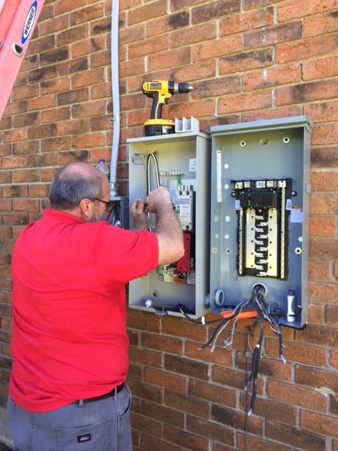 An electrician working on an outdoor electrical panel and meter box for Mr. Electric of Montgomery County Alabama in Montgomery, AL.